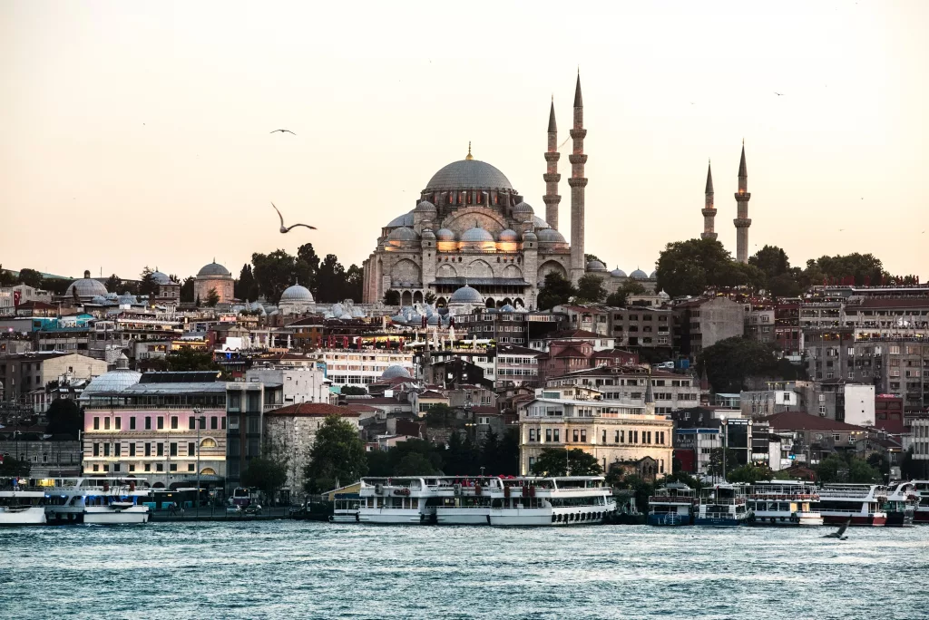 The historic skyline of Istanbul showing the Blue Mosque and Hagia Sophia during a golden sunset over the Bosphorus